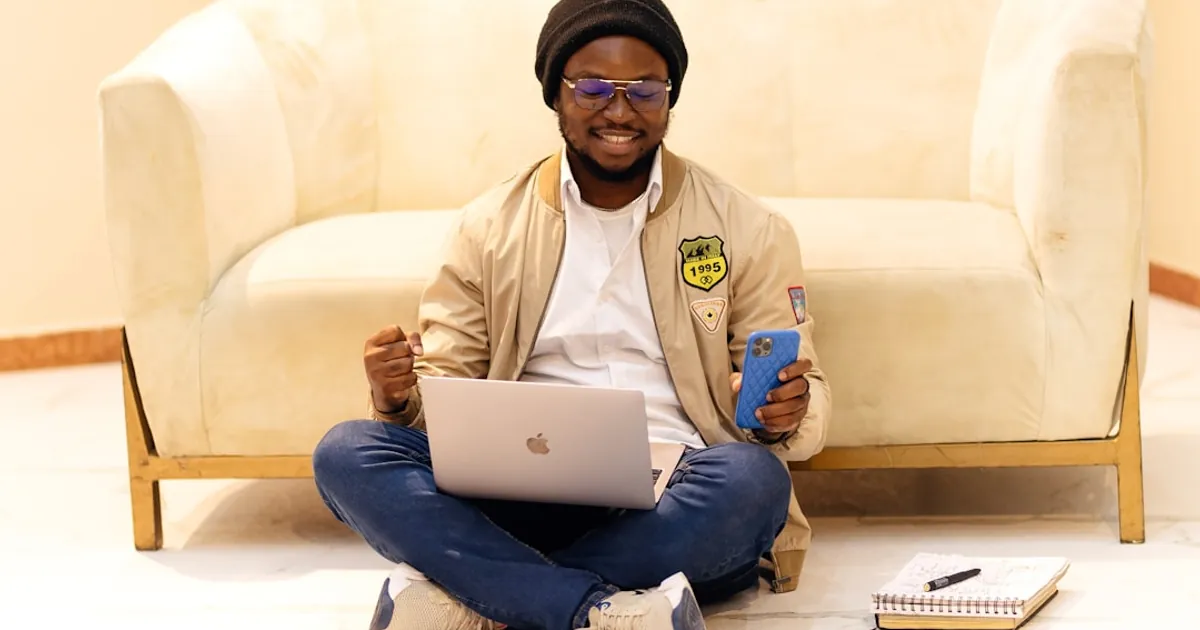 A man sitting on the floor using a laptop