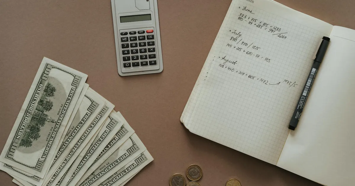 Flat lay with calculator, notebook, and US dollars ideal for financial concepts.