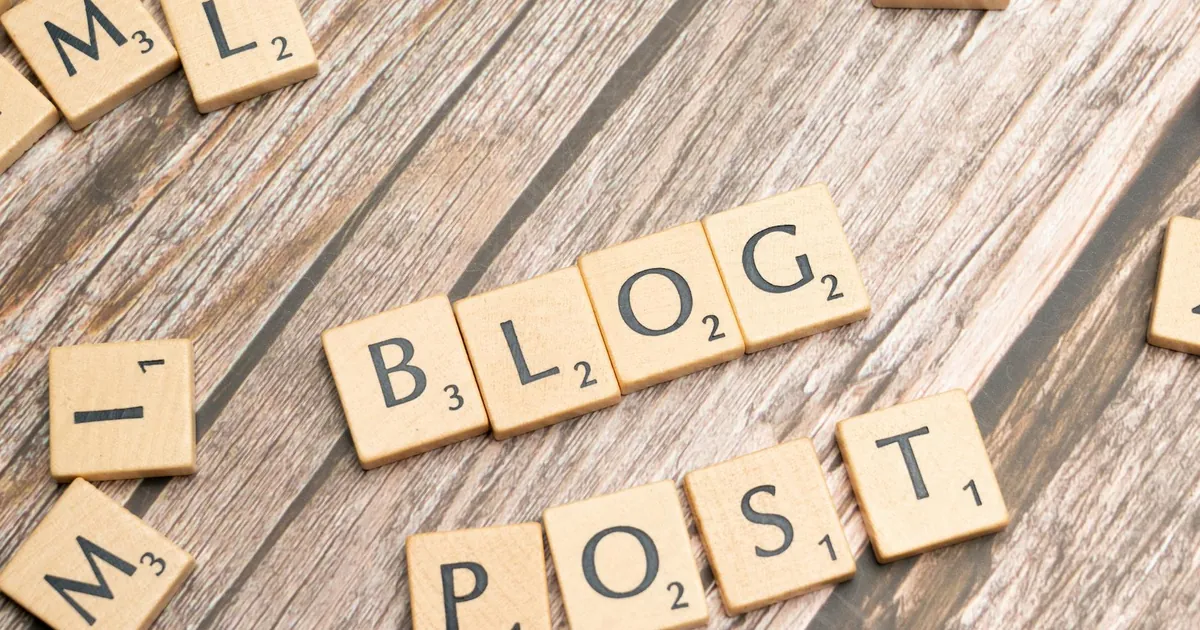 Wooden letter tiles spelling 'Blog Post' on a wooden background, ideal for online media concepts.
