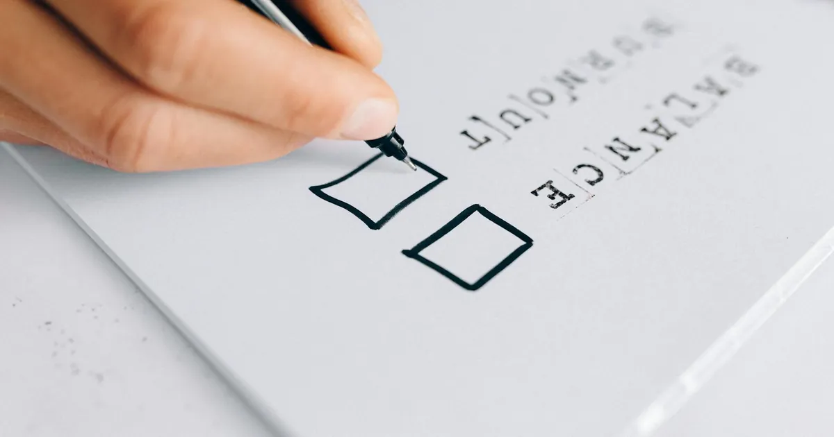 A hand drawing checkboxes on a checklist, themed around balance and burnout.