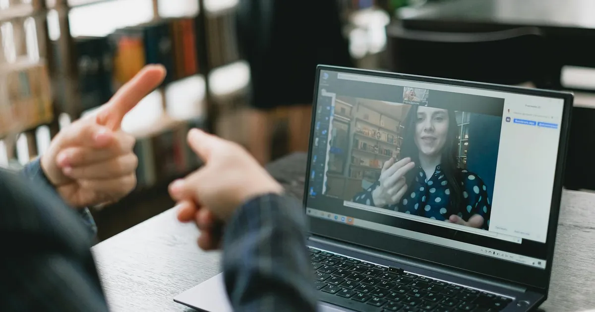 An online video call showcasing sign language communication between two individuals.
