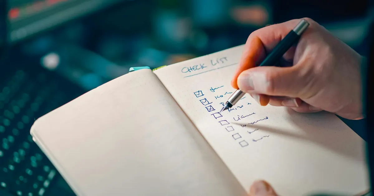 Close-up of a hand writing in a notebook with a checklist for effective task management. Close-up of a hand writing in a notebook with a checklist for effective task management.