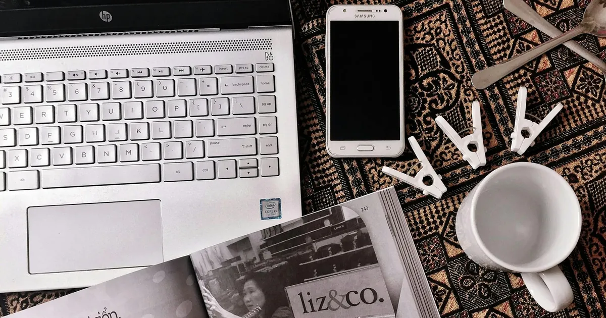 Artistic flat lay featuring a laptop, smartphone, and clothespins on a textured background. Artistic flat lay featuring a laptop, smartphone, and clothespins on a textured background.